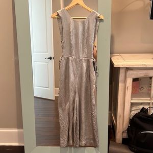J.O.A. Los Angeles silver jumpsuit. Open back, tie sides, sits above the ankle